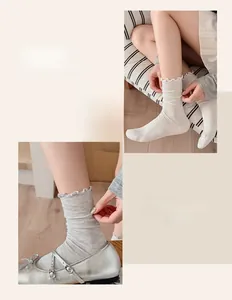 Close-up of ballet-style ruffled cuffs on silk rib-knit crew socks for women
