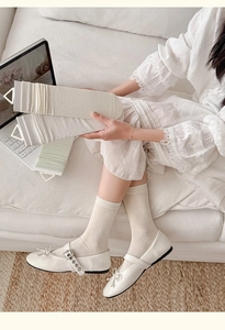 Detailed view of hollow-out mesh silk socks with ribbed cuffs and bow-knot patterns