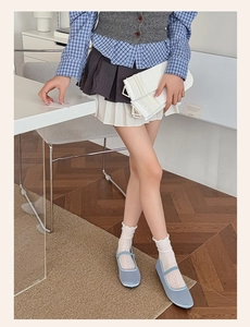 Vue détaillée de chaussettes en dentelle blanche avec des ballerines Mary Jane bleues