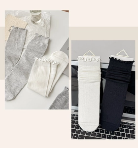 Detail of ruffled cuffs on gray, white and black ballet style crew socks for women