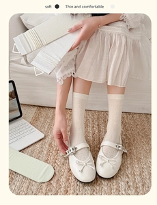 Close-up of cream bow-knot mesh socks with hollow patterns on model for spring