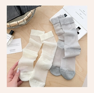 Close-up of sheer breathable ankle socks in beige and grey with fine vertical stripes