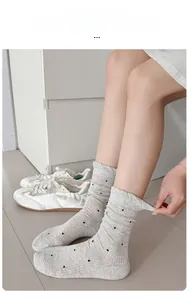 Detailed view of grey polka dot crew socks featuring high elastic ribbed knit texture