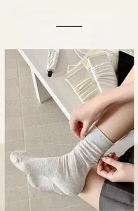 Detailed view of elastic ribbed cuff on breathable light grey cotton blend socks