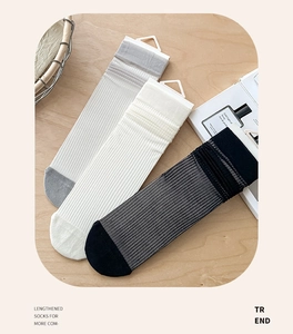 Detail of ribbed knit crew socks in grey and white showing elastic texture and soft fabric