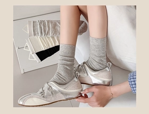 Detailed close-up of gray, beige, and black cotton socks with velcro sneakers