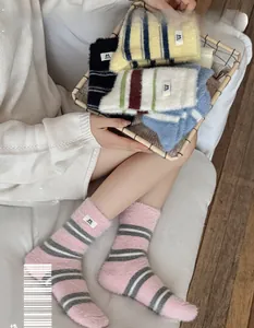 Close-up of fluffy striped mink velvet thermal socks for women in soft pink and grey tones