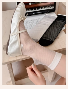 Detail view of sheer striped crew socks in beige, gray, and black colors with ballet flats