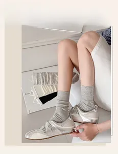Close-up of ribbed cotton crew socks in grey, white, and black with vintage sneakers