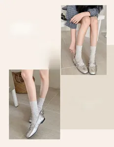 Detail of silver Mary Jane flats with bow, paired with breathable cotton crew socks