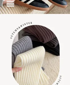 Detailed texture of rib-knit leg warmers in cream, grey and brown for autumn winter