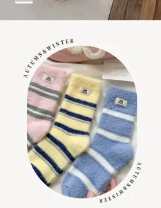 Detailed view of thick striped mink fleece socks with embroidered cat patches and labels