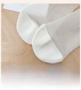 Detail shot of white semi-transparent mesh socks featuring reinforced toe and ribbed knit texture