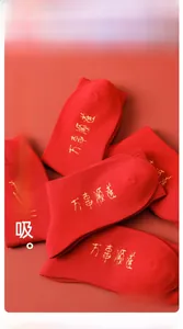 Detail view of red cotton mid-calf socks with golden Chinese embroidery for luck