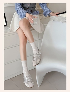 Detail of silver metallic trainers with dual velcro straps and stylish crew socks
