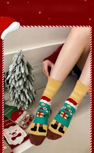 Close-up of Christmas cotton socks with tree patterns and Our Gift text on the ankle