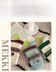 Detailed knit texture of thick striped socks with cute bear embroidery for winter
