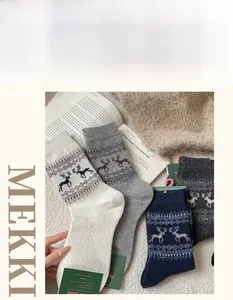 Close-up of Fair Isle wool socks with reindeer and snowflake jacquard patterns