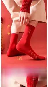 Close-up of red mid-calf socks featuring gold embroidery and high-elasticity cuffs