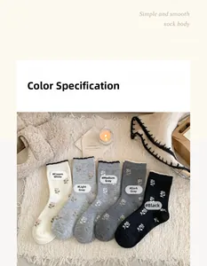 Flat lay of five pairs of floral cashmere socks in neutral shades on a cozy rug