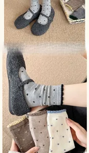 Close-up of winter wool socks featuring heart-shaped polka dots and ruffled knit edges