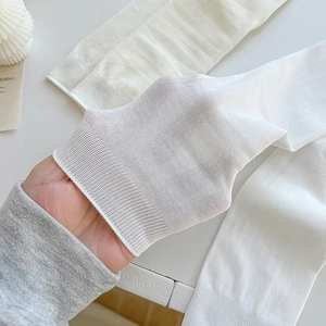 Breathable white cotton mid-calf socks shown stretched to display thin elastic fabric