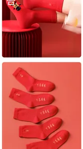 Close-up of red crew socks featuring golden embroidery patterns for Lunar New Year luck