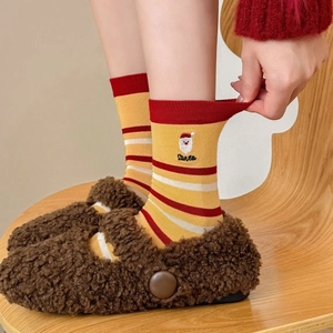 Christmas striped cotton socks with Santa Claus embroidery worn with fuzzy brown shoes