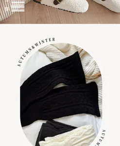 Detailed close-up of knitted leg warmers in white and black cable knit fabric