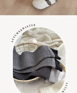 Detail of color-block knit leg warmers in grey and black inside a vintage wire basket