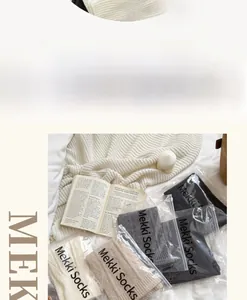 Macro shot of knitted ballet style leg warmers in various neutral colors with brand logo