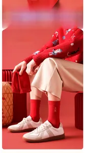 Close-up of red New Year cotton socks with gold embroidery and traditional decor