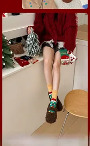 Close-up of ginger Christmas socks with tree patterns and knit holiday greeting details