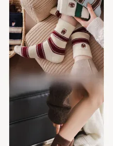 Detailed close-up of thick striped knit socks with cute teddy bear embroidery detail