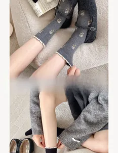 Detailed view of dark grey cashmere socks with floral embroidery and white wavy edges