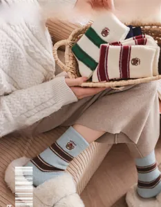 Détail de la broderie ours et texture en tricot rayé sur chaussettes d'hiver chaudes