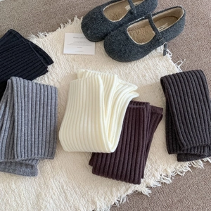 Winter knitted leg warmers in grey and cream colors with classic ribbed texture