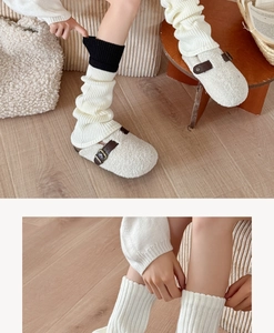 Detail of cream rib-knit leg warmers with black contrast trim and fleece clogs