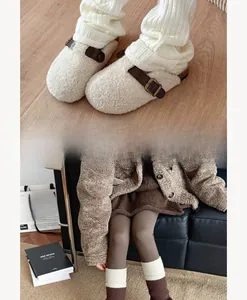 Detail of flared grey patchwork leg warmers paired with white plush slippers and warm socks