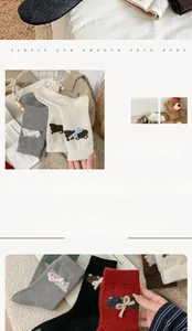 Detailed knit texture of wool socks featuring a 3D teddy bear pattern and ribbon bow