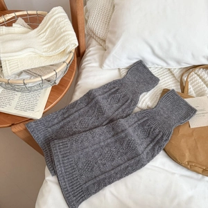 Grey ribbed knit leg warmers in ballet style with cozy texture on white bedding