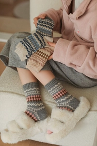 Detail of Nordic Fair Isle geometric wool socks with elastic ribbed cuffs and thick texture