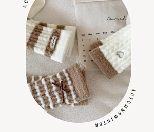 Détail de chaussettes rayées chaudes avec broderie cœur et nœuds sur tissu douillet