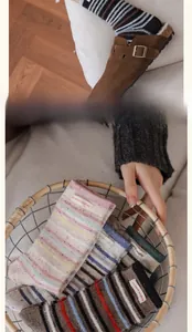 Close-up of thick striped wool socks with textile labels in a basket and worn with clogs