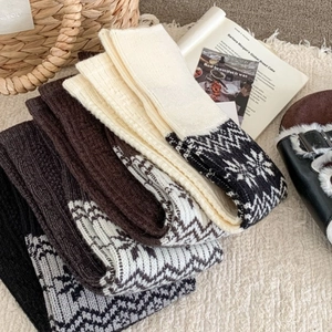 Cozy Fair Isle knitted leg warmers with Nordic snowflake patterns in neutral colors