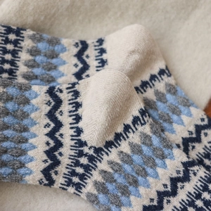 Close-up of thick knitted wool socks with Nordic Fair Isle patterns and geometric texture