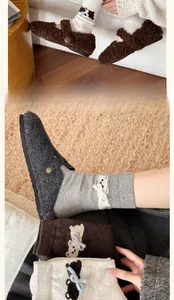 Detail of wool socks with cute animal embroidery and 3D bow accents in neutral colors
