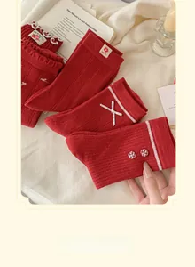 Détails de chaussettes en tricot rouge avec nœuds en satin blanc et étiquette brodée