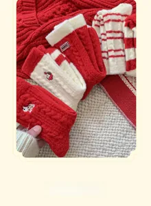 Detailed embroidery of a bear on thick red and white thermal wool socks for winter