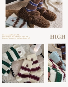 Détail de chaussettes rayées en peluche avec broderie ours et chaussons d'hiver chauds